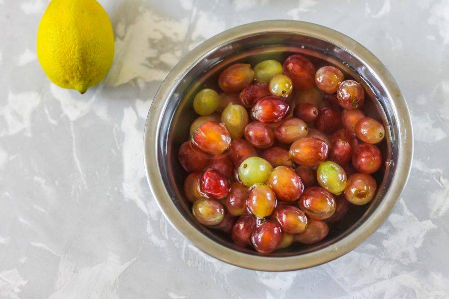 Отделите ягоды винограда от кистей, промойте их в воде.