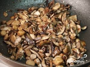 Согреть сковороду с растительным маслом и на сильном огне, помешивая, обжарить грибы до румяного цвета. 
Добавить лук и морковь, обжаривать еще несколько минут. 