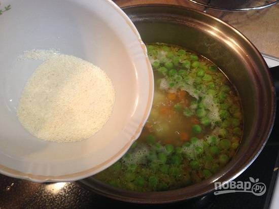 7. Отправляем манку, всыпаем тонкой струйкой, при этом помешивая суп. Варим суп еще минуты 3-4.