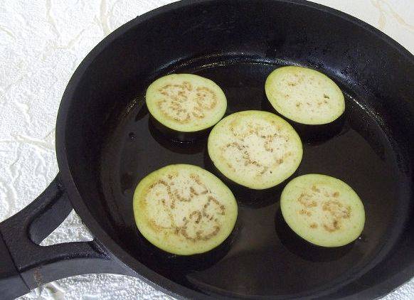 Затем баклажаны снова немного посолите и обжарьте с двух сторон до золотой корочки на сковороде. 