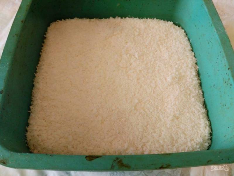 Смешайте кокосовую стружку и оставшийся сахарный песок (50 грамм), затем распределите сухую смесь по поверхности пирога. 