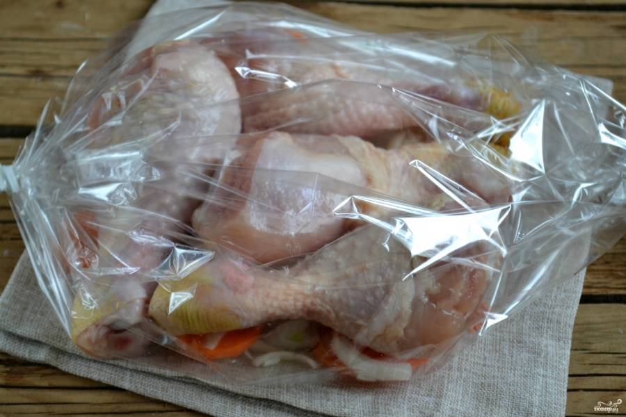 Сложите в рукав овощи, а на них выложите куриные голени. Завяжите рукав с обеих сторон и отправьте в духовку на 30 минут. За 10 минут до готовности рукав сверху разрежьте, чтобы на курице образовалась румяная корочка.
