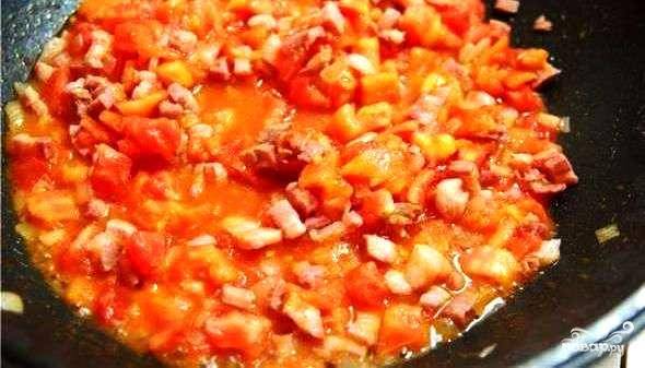 Когда лук и бекон хорошенько обжарятся, добавляем к ним мелко нарезанные помидоры. Солим, перчим и тушим около 5 минут.