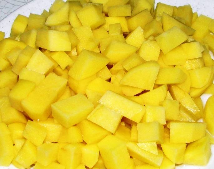 Картофель порежьте кубиками и бросьте в кастрюлю к гороху.