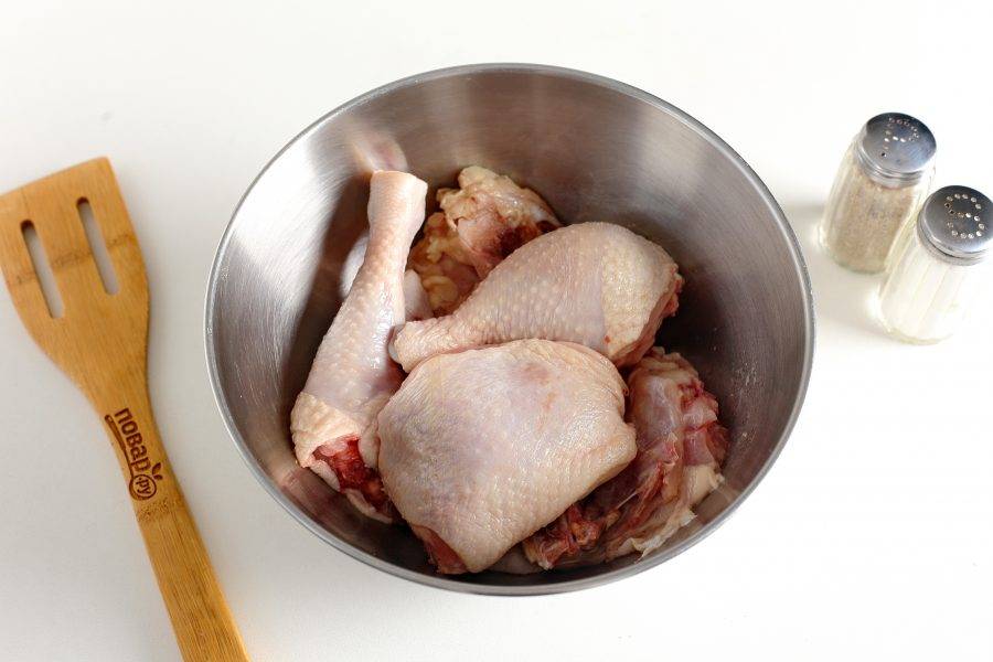 Курицу нарежьте на части и сложите в глубокую миску.