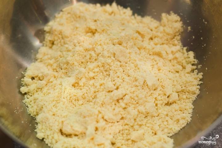 Холодное масло или маргарин режем кусочками и выкладываем в посуду, в которой будем делать тесто. Добавляем муку, соль, 0,5 стакана сахара и разрыхлитель. Перетираем все эти ингредиенты до состояния крошки.