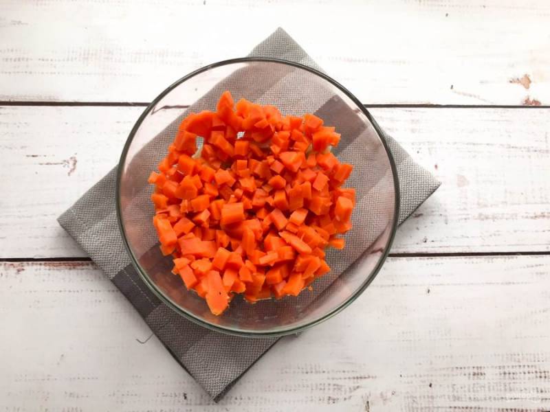 Вареную морковь почистите, нарежьте кубиками и добавьте к картофелю. 