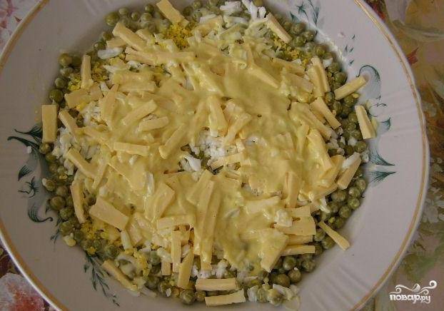 Снова небольшой слой майонеза и далее добавляем размельченный чеснок и белок и снова тонкий слой майонеза. Затем разложить сыр.
