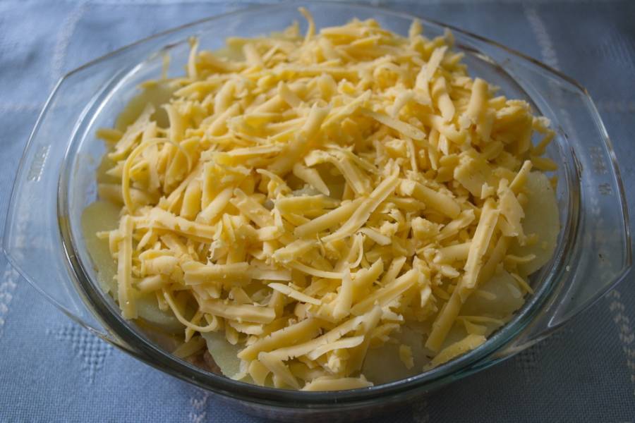 Влейте 200  мл сливок (15 %). Натрите на терке твердый сыр. Выложите сверху.