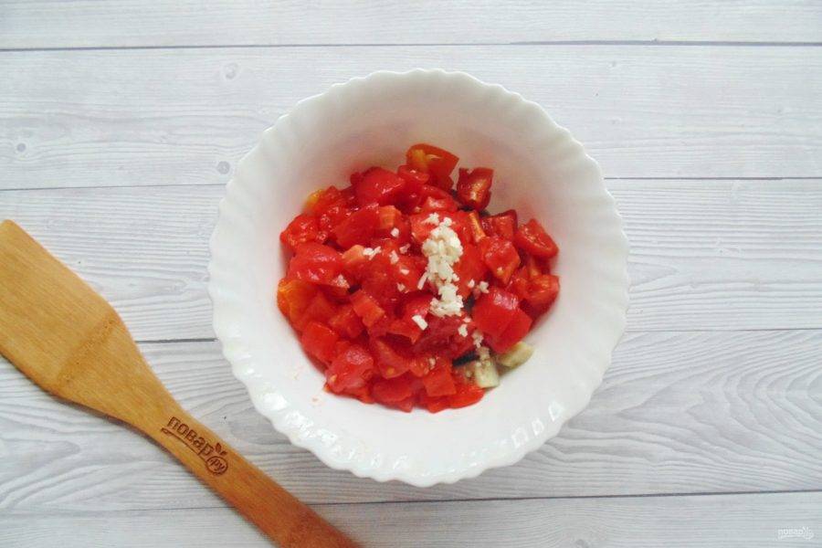 Нарежьте помидоры и вместе с измельчённым чесноком добавьте в салатник.