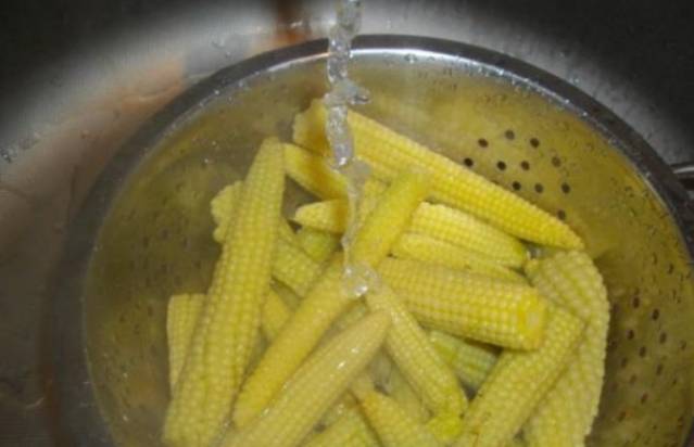 Откидываем сваренную кукурузу на дуршлаг. 1 минуту держим под проточной холодной водой.
