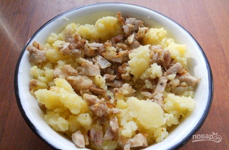 Отваренный и толчёный картофель смешайте с зажаркой. Добавьте масло, чтобы начинка лучше перемешалась. Посолите и поперчите начинку.