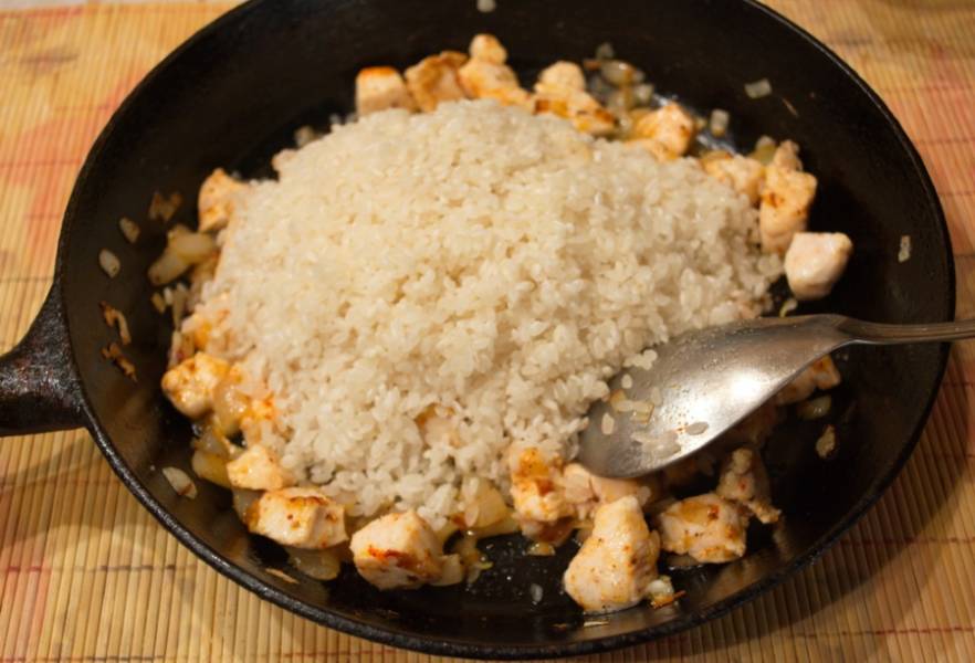 Промыть рис до чистой воды. Сырой рис кладем в сковороду к курице. Перемешиваем сразу и накрываем сковороду крышкой на 3 минуты.