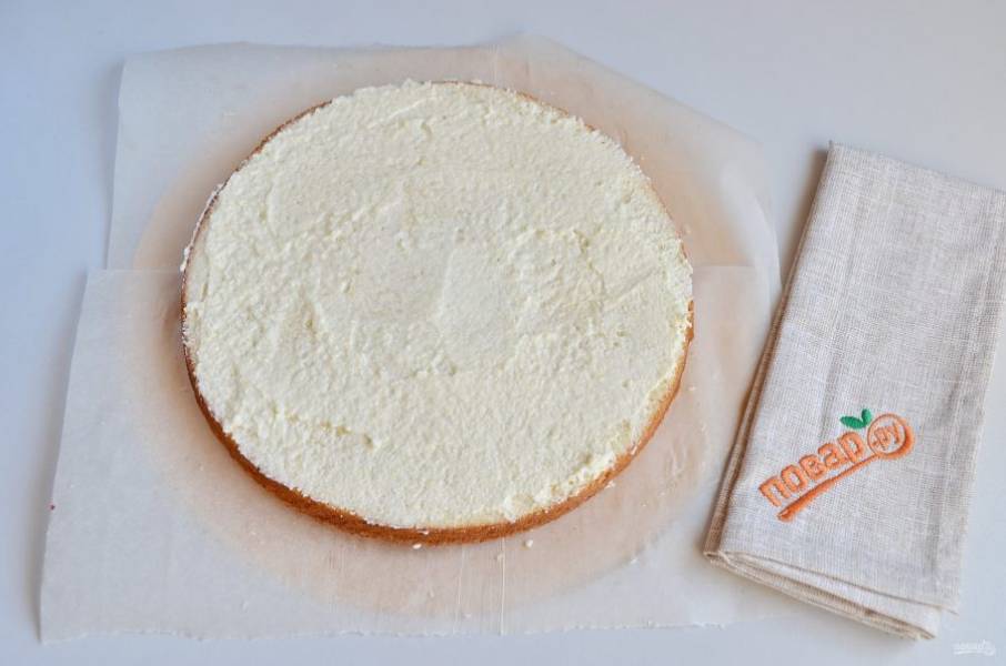 12. Остывший бисквит разрежьте на две части. Пропитайте каждую половинку сладким сиропом. Потом смажьте половиной крема.