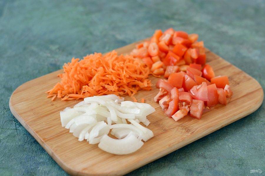 В это время натрите морковь на терке, лук нарежьте полукольцами, а помидор и перец кубиками.