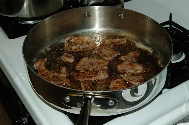 После того как масло перестанет пениться положите говядину на горячую сковороду. Поджаривайте мясо с обоих сторон до слегка коричневого цвета. 