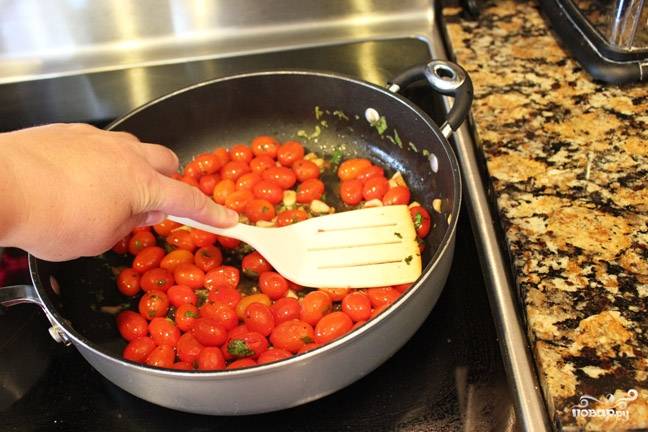Смешайте помидоры с зеленью и добавьте бальзамический уксус. Разогрейте сковороду, налейте в неё оливкового масла и выложите помидоры.