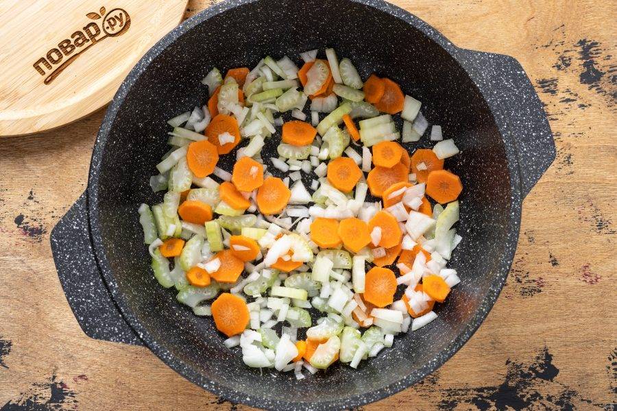 Разогрейте в сковороде растительное масло. Добавьте нарезанный кубиками репчатый лук, сельдерей и морковь. Обжарьте до золотистого цвета.