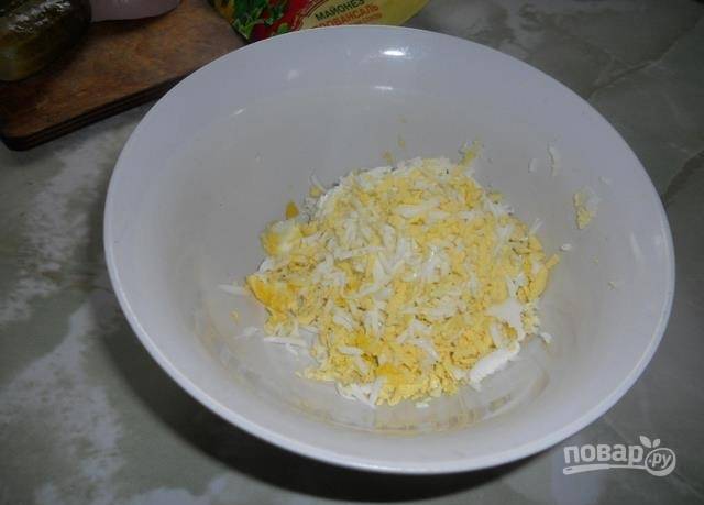 1. Сварите вкрутую куриные яйца, натрите их на крупной терке. 