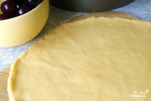 Масло разотрите с 1 чайной ложкой ванильного сахара и 1/3 стакана сахарной пудры, также добавьте желток. Осторожно всыпая муку, замесите тесто. Затем раскатайте его в круглый пласт.