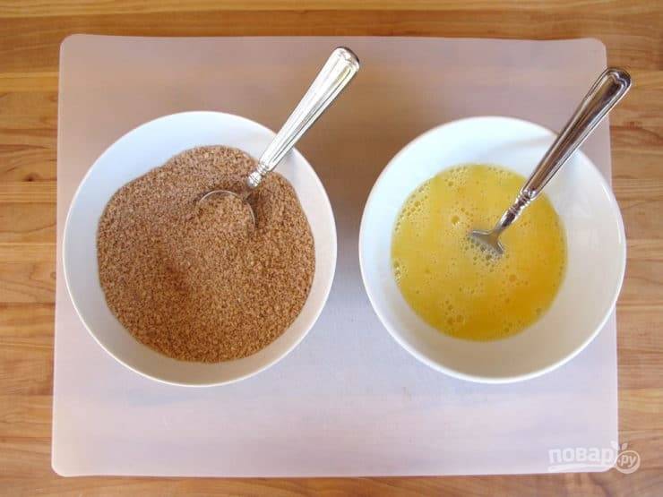 2. Подготовьте две тарелки. В одной смешайте яйца с водой, а в другой сухари с солью, паприкой и кунжутом.