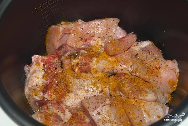 Курицу посолим, поперчим, добавим карри. Поставим мясо готовиться на 25 минут в режиме выпечка.
