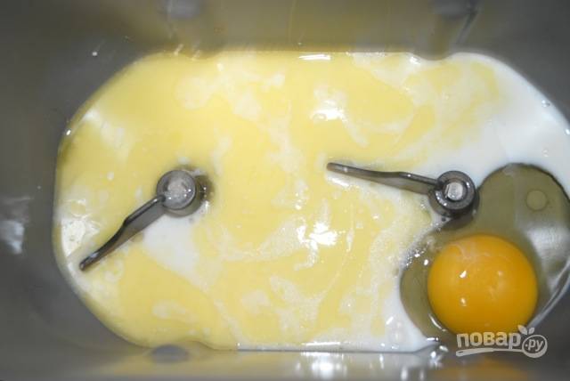 1. Для приготовления теста в хлебопечке на дно ведерка отправьте теплое молоко, яйца и предварительно растопленное сливочное масло.