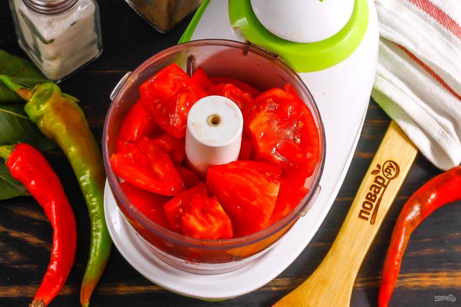 Помидоры промойте в воде и вырежьте из них сердцевинки. Если не любите, когда кожура попадается в соусе, то залейте томаты на 10 минут кипятком и затем удалите кожуру. Нарежьте на части и выложите в чашу измельчителя.