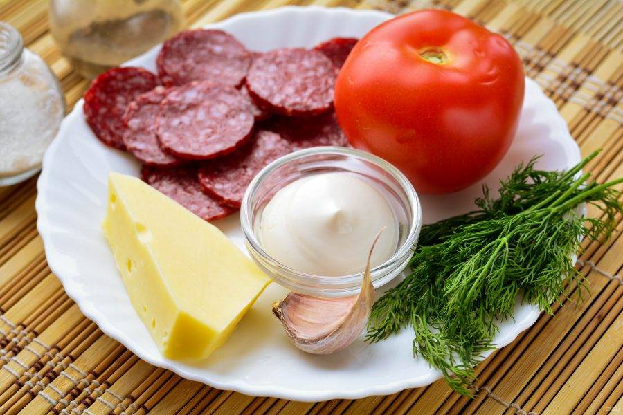 Подготовьте ингредиенты для приготовления грузинского салата с колбасой и помидорами.