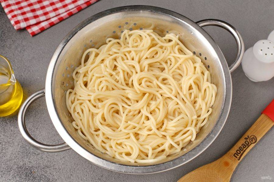 Спагетти отварите в подсоленной воде согласно инструкции на упаковке, затем откиньте на дуршлаг. Я обычно отвариваю пасту параллельно приготовлению соуса, что значительно экономит время.