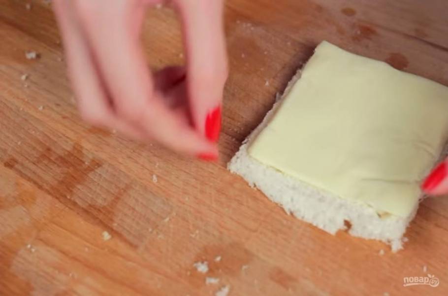 2. Выложите на него ломтики плавленного сыра (можно хлеб слегка смазать взбитым яйцом, чтобы при жарке он получился более хрустящим). 