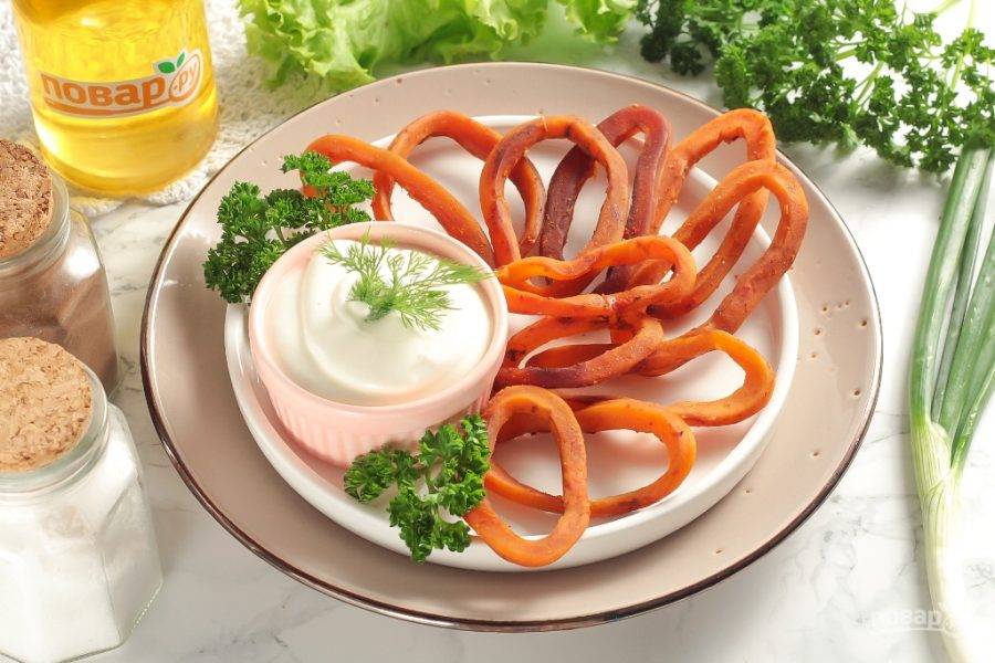 Выложите вяленые кольца кальмара на тарелку и подайте со вкусным чесночным соусом или соусом тартар.