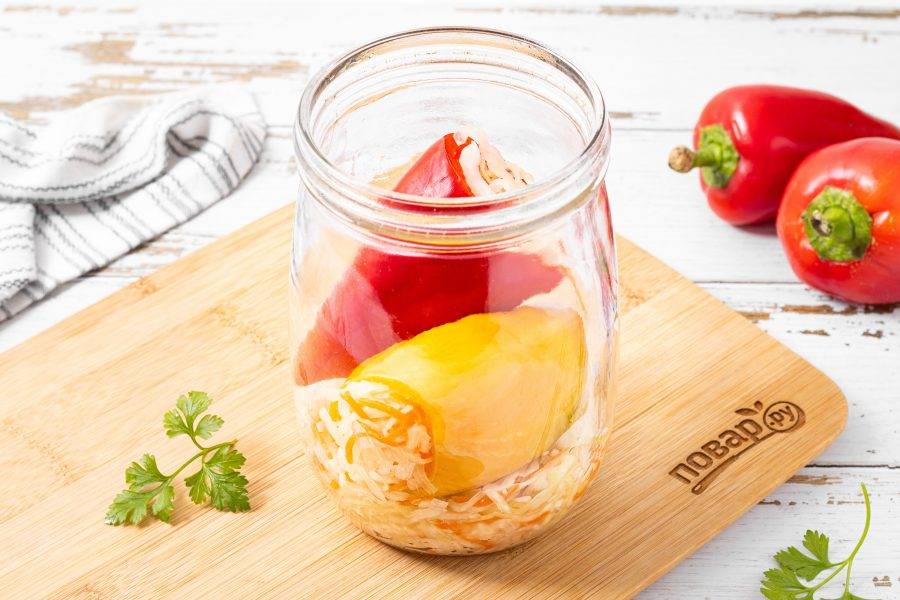 Затем начните выкладывать перцы, а пустоты прокладывайте капустой. Укладывать нужно поплотнее, чтобы перцы и капуста была покрыта соком.