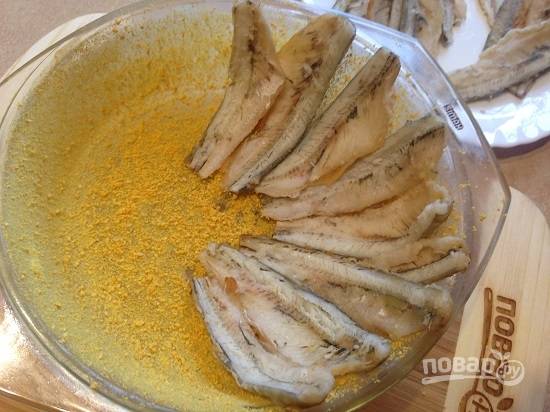 4. Форму для выпечки смазываем сливочным маслом и щедро посыпаем панировочными сухарями. А затем выкладываем филе рыбки.