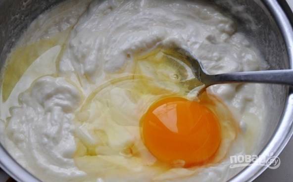 К растопленному теплому сливочному маслу добавьте сметану. Будет отлично, если вы отдадите предпочтение жирной домашней сметане. Тщательно перемешайте оба ингредиента, вбейте к ним сырое куриное яйцо. 