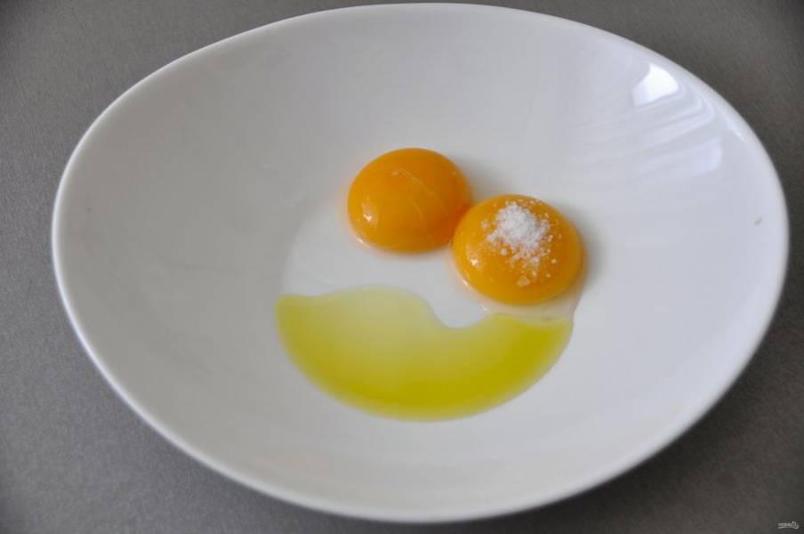 Пока варится бульон, приготовьте домашнюю лапшу, для этого потребуется одно целое яйцо или два куриных желтка, добавьте щепотку соли и столовую ложку оливкового масла.