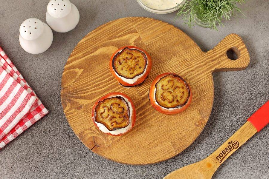 Смажьте помидоры чесночным соусом и сверху накройте кружочком баклажана. Баклажаны посолите и поперчите по вкусу.