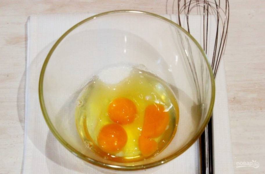 Возьмите глубокую миску, вбейте в нее три сырых куриных яйца. Затем добавьте к ним пару ложек сахара и немного соли. При помощи венчика взбейте ингредиенты, пока масса не станет однородной. 