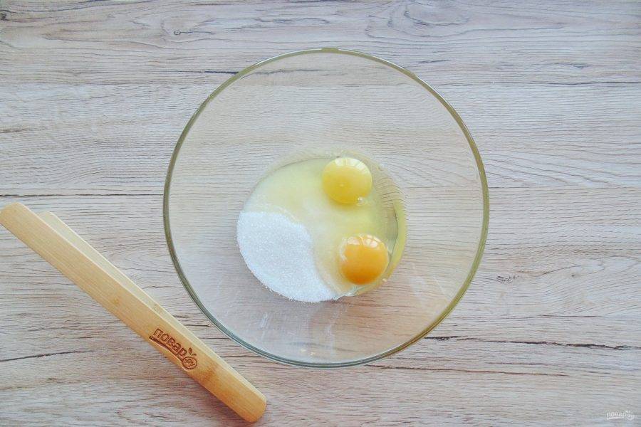 В миску насыпьте сахар, и разбейте яйца.