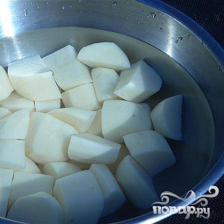 Почистить картофель, нарезать на средние ломтики. Поместить в кастрюлю и залить водой.