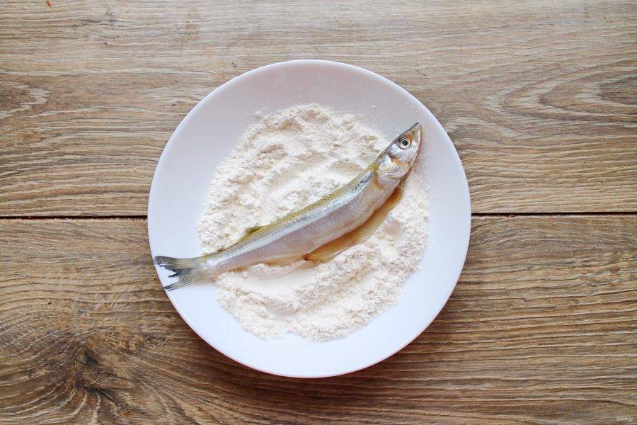 Смешайте муку с солью и полностью запанируйте в ней рыбу.