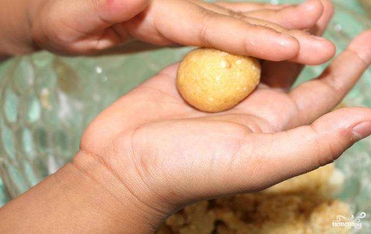 3. Теперь можно начать формировать арахисовое печенье в домашних условиях. Возьмите немного теста и скатайте шариком. Духовку к этому времени разогрейте до 160 градусов. 