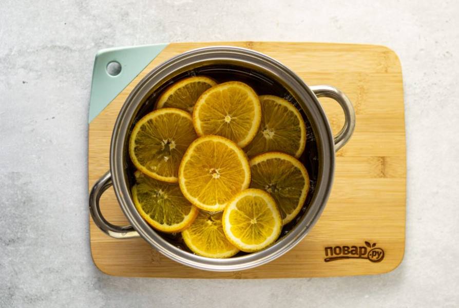 Переложите апельсины в кастрюлю с кипящим сиропом.