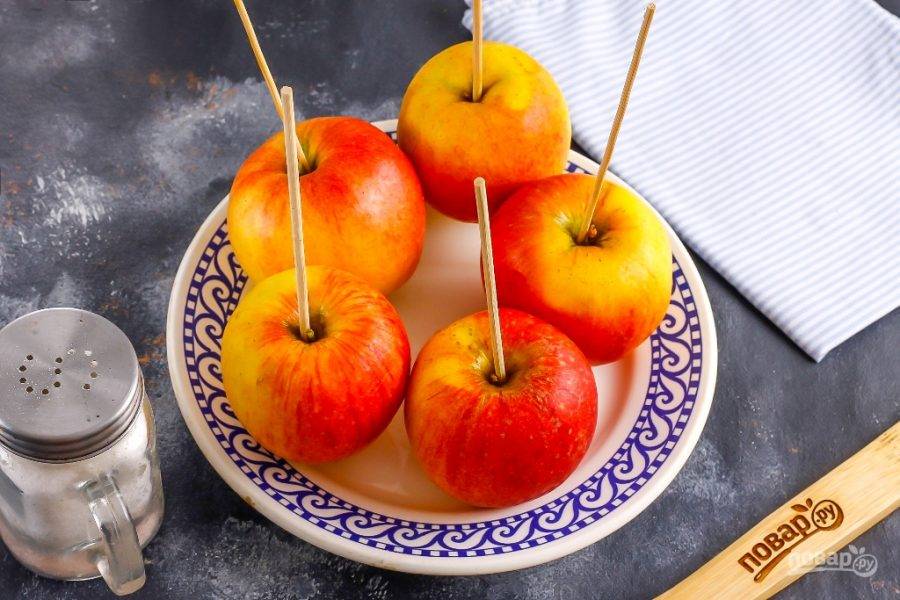 Удалите черенки и нанизайте яблоки на деревянные шпажки среднего размера.