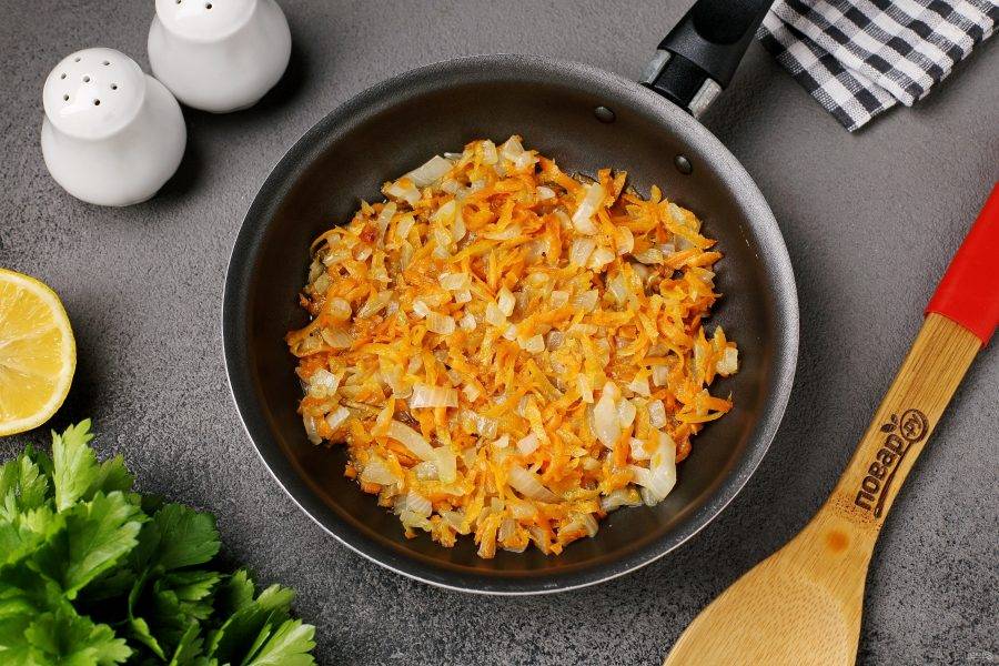 Лук нарежьте кубиками. Морковь натрите на тёрке. Обжарьте овощи в сковороде до мягкости. Посолите и поперчите по вкусу.