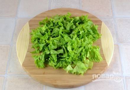 Листья салата промойте под проточной водой и обсушите. Затем нарежьте его на полоски. Также можно порвать салат руками. 