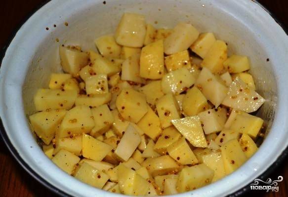 Добавьте горчицу с маслом и специями к кусочкам картофеля, тщательно все перемешайте. Поставьте в холодильник, предварительно накрыв крышкой, чтобы картошка успела промариноваться. Оставьте в холодильнике картошечку на пару часов.
