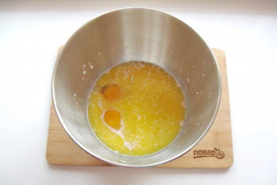 Сливочное масло растопите, немного охладите и добавьте в миску.