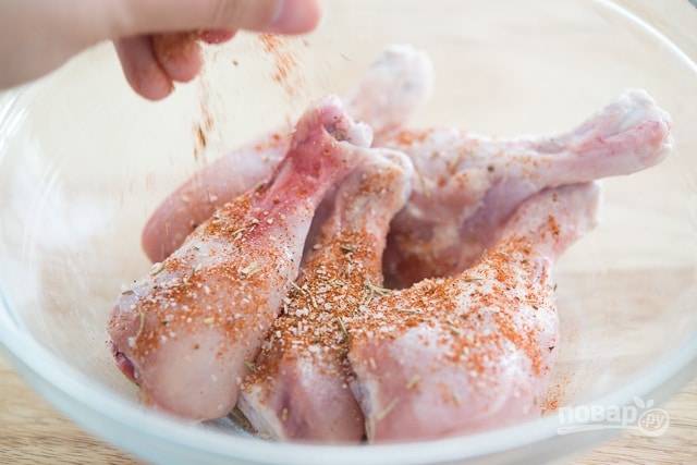 1. Для начала куриные ножки натрите солью, перцем, чесноком, травами и паприкой.