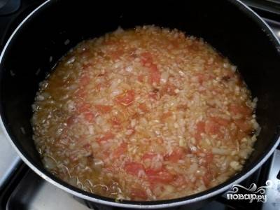 Затем добавьте помидор и изюм. Перемешайте и залейте кипятком, чтобы он накрыл рис. Готовьте под крышкой на медленном огне.